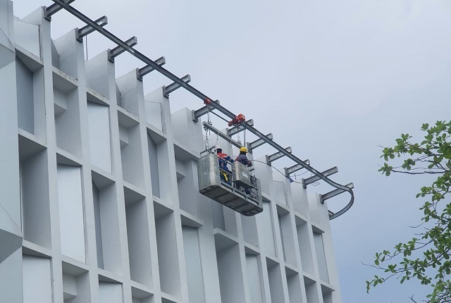 Pekerja sedang menggunakan gondola gedung milik PT Pola Gondola Adi Perkasa di gedung Pertamina Sholab, Balikpapan.